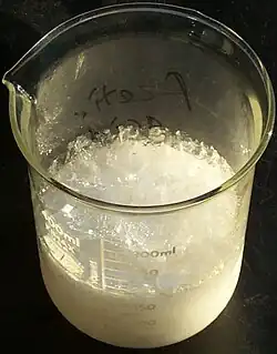 glass beaker of crystallized acetic acid