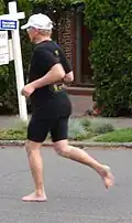 A barefoot runner on asphalt