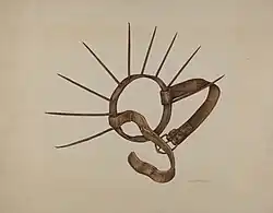 A ring with long metal spikes and two leather straps.