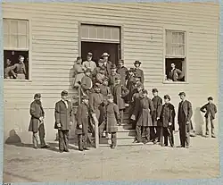 a group of hospital stewards and surgeons in uniform standing outside of a hospital.