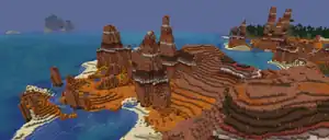 Eroded badlands next to an ocean.