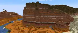 A large cliff in wooded badlands.