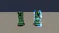 A charged creeper next to a normal creeper.