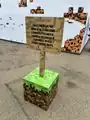 A real life version of a Minecraft sign on a grass block.
