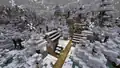 Snow falling on a snowy taiga hills village in Bedrock Edition.