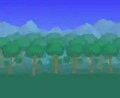 Grove of forest trees blocking mountains.