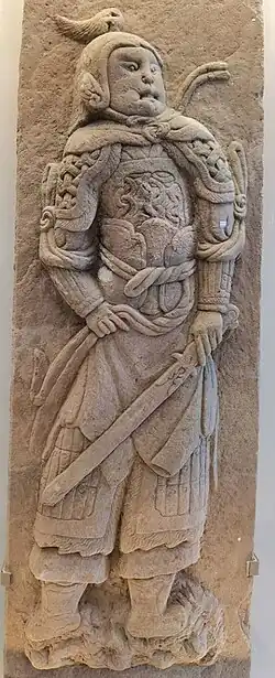 Song stone relief of a swordsman wearing mountain pattern and mail armour