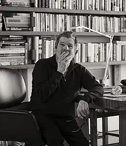 A three-quarters view of Wenner, seated and wearing a polo shirt