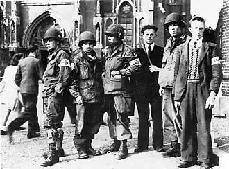 Members of the Dutch Resistance with troops of the US 101st Airborne Division in front of the Lambertus church in Veghel during Operation Market Garden, September 1944
