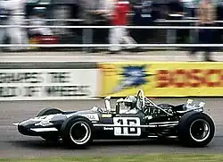 A mid-engined single-seater racing car with modest aerodynamic wings