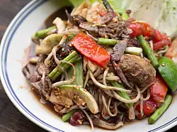 The fruit, of which the seed can easily be seen in this image, can also be used for making green papaya salad in Thailand and Laos
