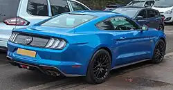 Rear three-quarters view of a light blue coupe