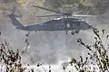 A U.S. Navy SH-60 Sea Hawk helicopter fills a bambi bucket with water during the annual Cory Iverson Wildland Firefighting exercise at the Las Pulgas Lake on Marine Corps Base Camp Pendleton, California, April 19, 2023.