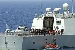 Aft-deck of frigate Yiyang (548) with PLAN and USN personnel, and a Harbin Z-9 helicopter