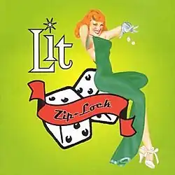 A young red-haired woman in a green dress does a pose while sitting on a big pair of dice.