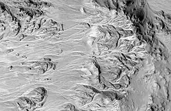 Alluvial Fans in Mojave Crater, as seen by HiRISE. High ground is on the right. Branched network of channels runs from higher ground (crater rim) to lower ground.