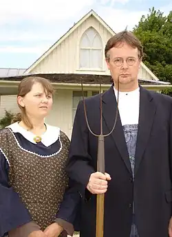 visitors wearing period-style clothing, and with props such as a pitchfork and glasses