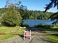 Lake and trees with a danger sign and red tape surrounding it