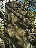 Stone pillar set on a plinth with a carving of a woman (possibly S. Astvatsatsin) adjacent to the church