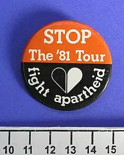 button badge, red top half, black bottom half with white text- STOP The '81 Tour above HART symbol; "fight apartheid"