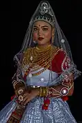 Adding jewelry can obscure or complicate the shape of a neckline. For example, this Meitei woman wears many necklaces as part of her traditional Bangladeshi Meitei clothing. These necklaces create the perception of a rounded neckline, despite the V-shaped neckline of the clothing underneath.