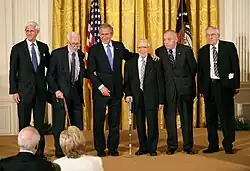Photograph of President George W. Bush alongside members of the MFAA as he presents the National Humanities Medal