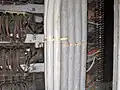 A Chicago stitch where some additional cables (grey plastic, left) have been added to an existing bundle (fabric cables, right).