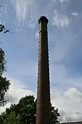 The 120-foot (37&nbsp;m) tall chimney, brick with oversailing caps