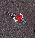 Rosette flanked both sides in silver, denoting the wearer has been awarded the Commander of the Legion of Honour