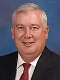 David R. Craig smiling on a blue background