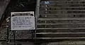 Sign at the bottom of the main staircase. Text translates: "Welcome to 'Japan's No. 1 Mole Station'" The staircase is 338 meters long and has 462 steps. Climb the stairs and go through the connecting passageway 143 meters (24 steps) to reach the ticket gate. The elevation of the down platform is 583 meters above sea level, while the station building is 653.7 meters, meaning the difference in elevation between the station building and the down platform is 70.7 meters. It takes about 10 minutes to reach the ticket gate. Please be mindful of your step when entering."