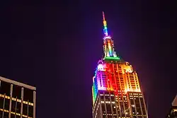 The Empire State Building illuminated by rainbow-colored lighting at night
