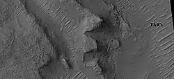 Layers in depression in crater, as seen by HiRISE under HiWish program A special type of sand ripple called Transverse aeolian ridges, TAR's are visible and labeled. Location is Hellas Planitia in Noachis quadrangle.