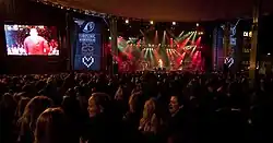 People standing in front of a stage where a band is performing