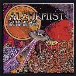 A scene from War of the Worlds. Three flying saucers are above a war torn area. The lead one is shooting two rays below them. The undergrowth is afire. Behind the saucers is a huge moon. At the top right is the artist's name in large white and black-bordered print. Below in smaller but similar all caps is the album title. Below that is the additional phrase "From Jeff Wayne's War of the World".