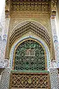 Decoration on the outer south wall of the mausoleum, and a slot opening (bottom) for giving alms