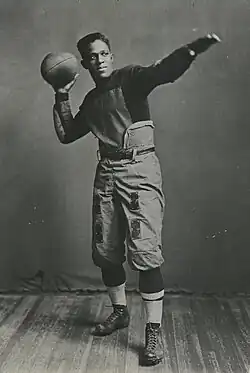 Fritz Pollard, posing with a football