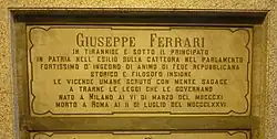 A marble gravestone on the wall of a crypt