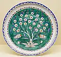 Dish with a prunus tree reserved in white on a green ground, c. 1585