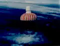 A KH-9 re-entry module hanging from its parachute, ready to be retrieved.