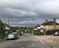 View down Henrys Avenue showing the architecture typical of the Highams Estate, and its proximity to the City of London, visible on the horizon.