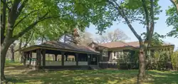 brown one-story wooden building with attached outdoor covered seating area