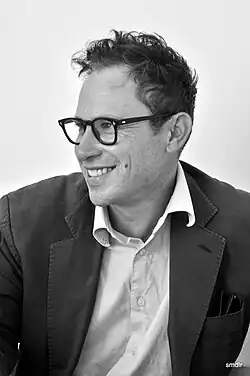 Hopkins smiling in a black-and-white photo, wearing a suit