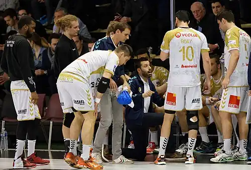 Joël da Silva and his players during a timeout.