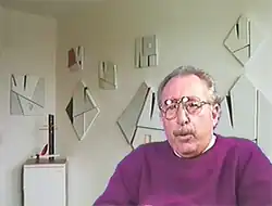 Juan Melé in front of several of his paintings.