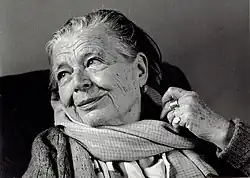 Photographie noir et blanc d'une veille femme aux yeux pétillants qui sourit.