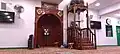 The qibla wall, in the prayer hall of the mosque. The wooden mihrab and minbar are visible.