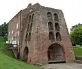 Moira Furnace with the furnace stack at the front and the bridgehouse building at the rear, originally there would have been a casting shed in front of the furnace where the iron 'pigs' were produced