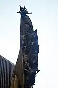 Multiple sculptures representing people striving to reach the monument's summit.