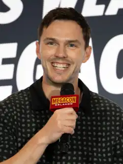 A young, Caucasian man with short, dark hair and facial stubble.